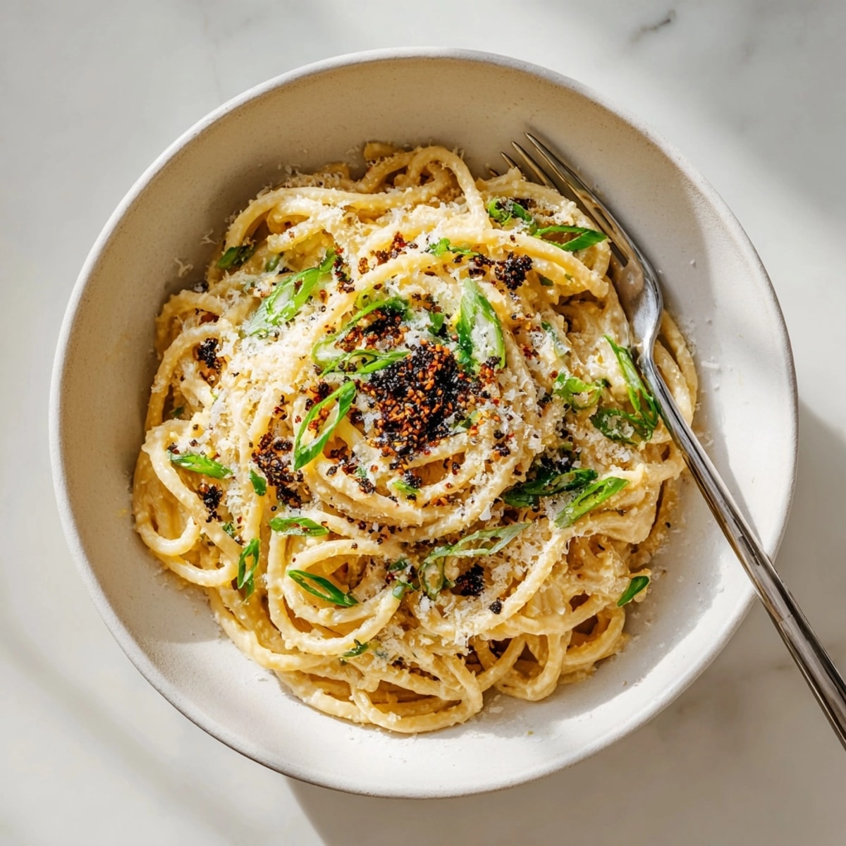 Close-up of a flavorful bowl of Miso Butter Bucatini, ready to eat, with a garnish of savory nori.