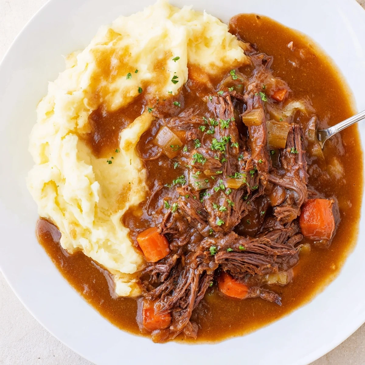 Slow Cooker Pot Roast with Mashed Potatoes served with rich gravy and fresh herbs.  