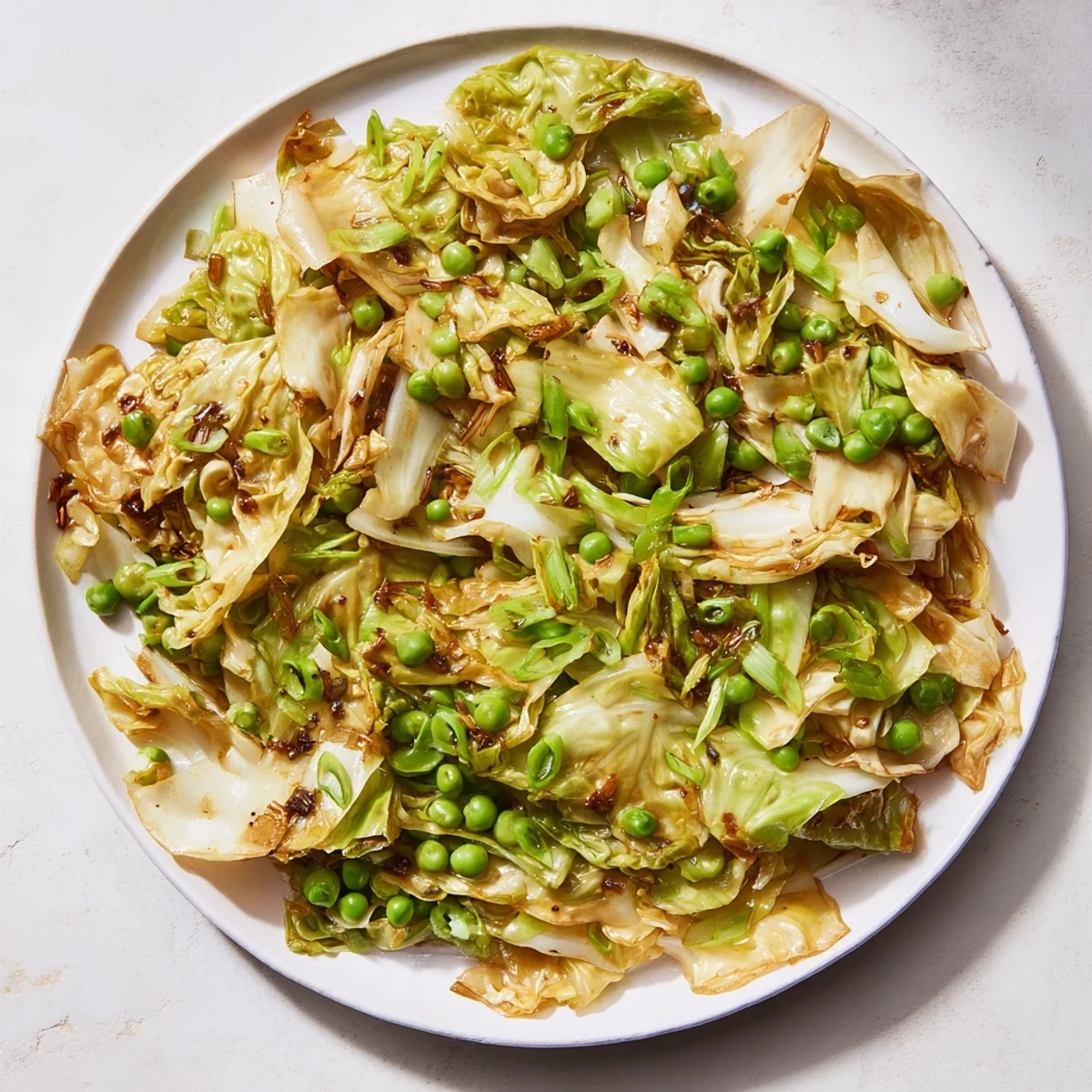 Steaming Cabbage Stir-Fry with Garlic tossed with vibrant green peas and savory soy sauce.