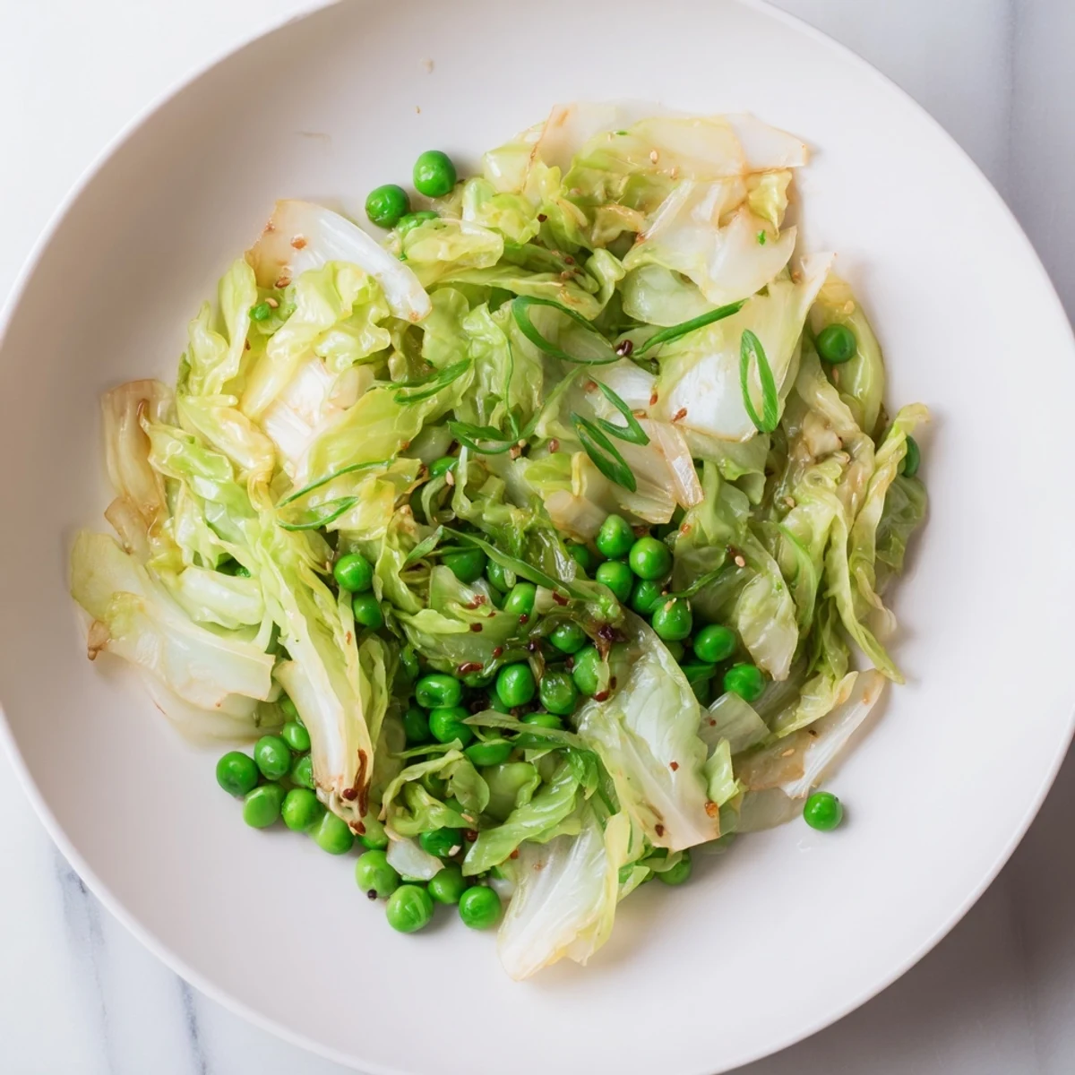 Ready-to-eat Cabbage Stir-Fry with savory garlic, soy, and tender green peas; a perfect side.