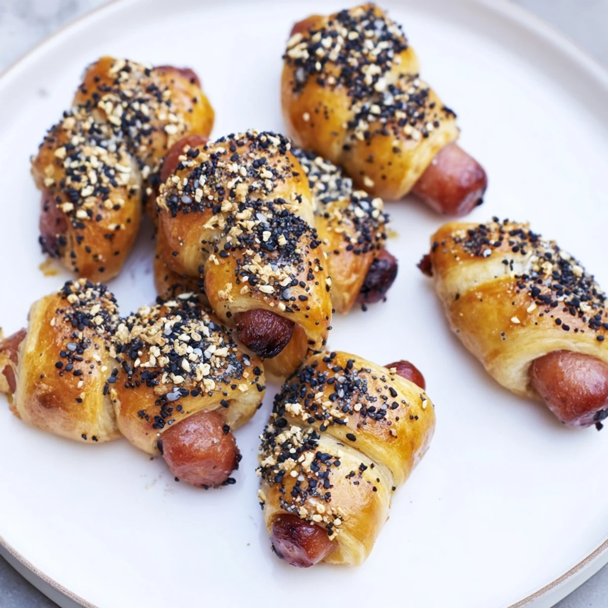 Golden baked Everything Bagel Pigs in a Blanket, ready to serve with a dipping sauce.