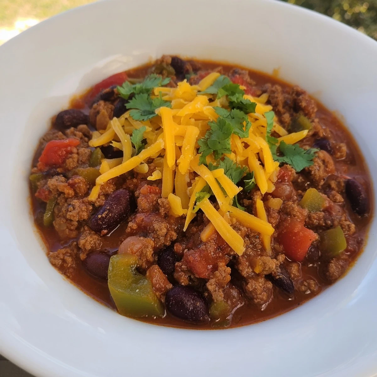 A close-up of a flavorful quick chili with canned beans: red sauce, and hearty meat pieces.
