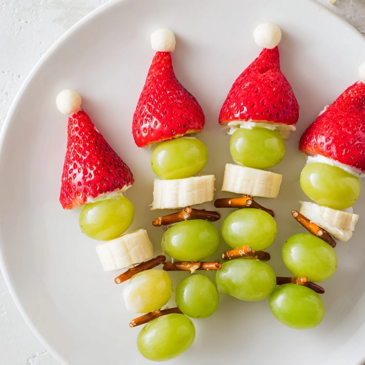 Freshly assembled Elf Hat Strawberry Skewers are ready to serve, featuring juicy berries and banana rounds.