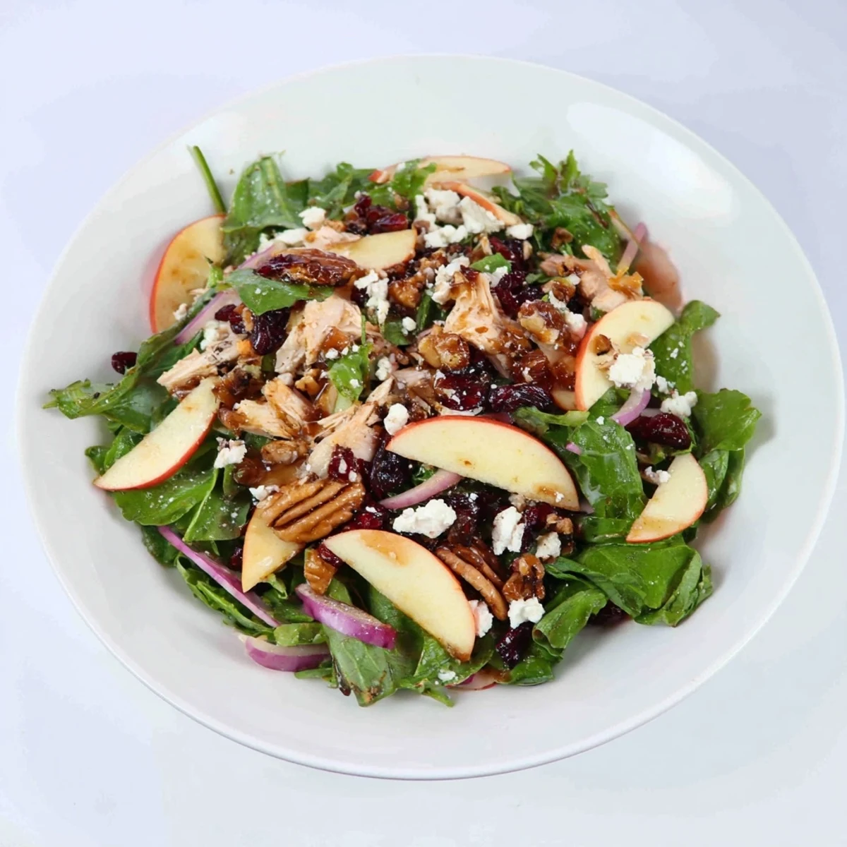 A colorful bowl displays this Chicken and Apple Winter Salad, ready to enjoy on a chilly day.