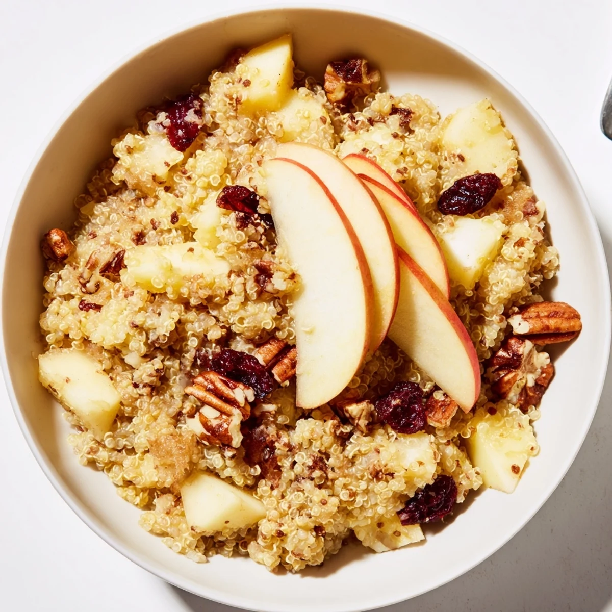 Close-up of a warm Apple Cinnamon Quinoa Bowl, inviting with cinnamon scent and diced apples.