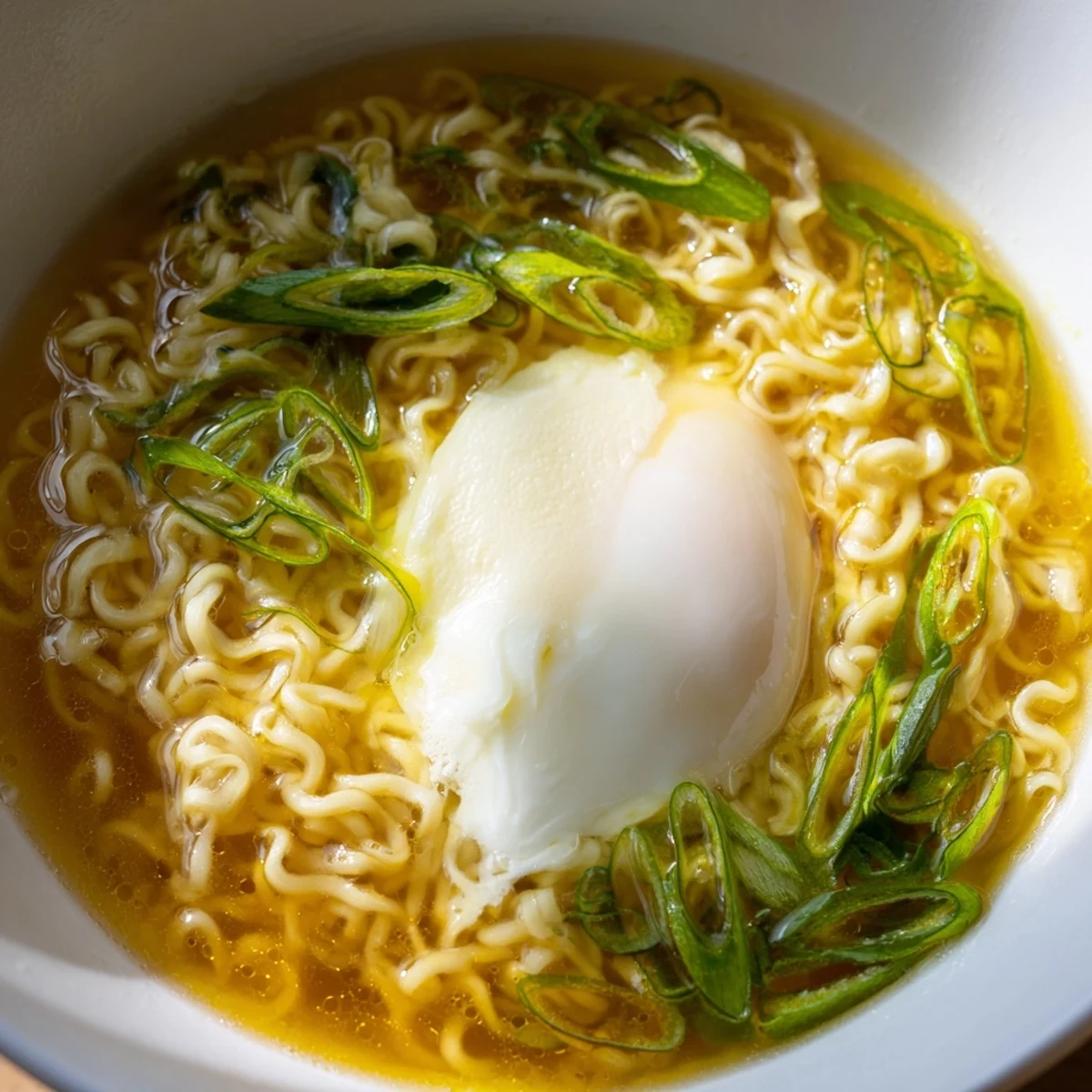 Enjoy a comforting bowl of upgraded instant ramen with a runny egg, scallions, creating a flavorful, budget-friendly meal.