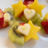 Vibrant, star-shaped strawberry and heart kiwi Midnight Kiss Cocktail garnishes for festive drink presentation.