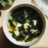 Bright green wakame seaweed and cubed tofu float in a delicate Japanese broth, creating a simple, nourishing bowl of traditional Wakame Soup.