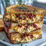 Classic Southern pimento cheese spread layered between crustless white bread slices, ideal for elegant tea parties.  