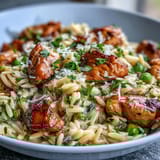 Bright, zesty lemon orzo skillet dinner with juicy chicken, vibrant peas, and a sprinkle of Parmesan for extra richness.  