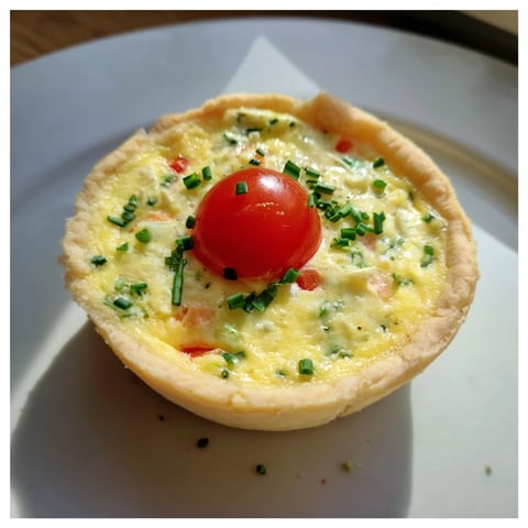 Golden-brown Couronne Florale Mini Quiches, filled with colorful vegetables and creamy cheese filling, ready to serve.