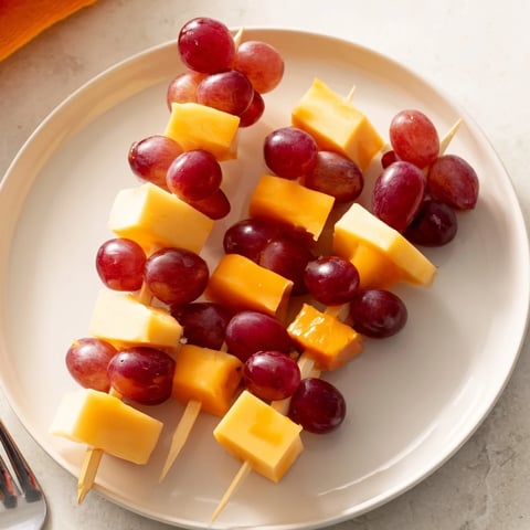 Cheese and grape skewers arranged beautifully on a platter, ready to grab for a tasty snack.