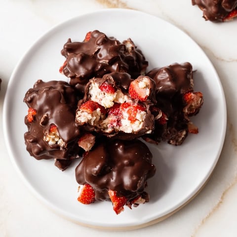 Frozen Strawberry Yogurt Clusters, a mix of chocolate-covered delights ready for snacking.