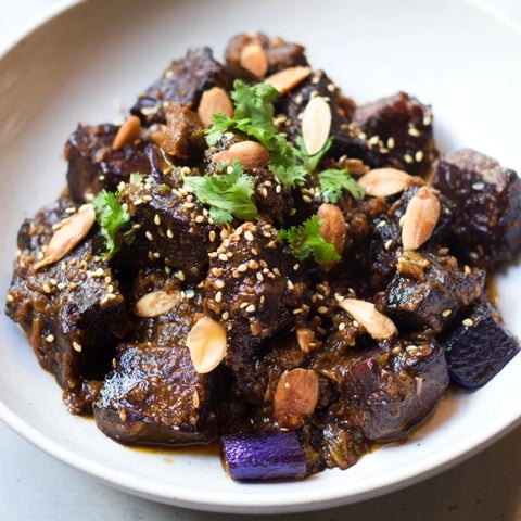 Savory Moroccan Lamb Tagine, richly flavored with prunes and almonds, simmering in a spiced sauce.