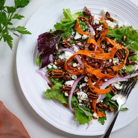 Tender roasted carrot ribbons on a bed of fresh mixed greens, topped with honey-mustard vinaigrette.