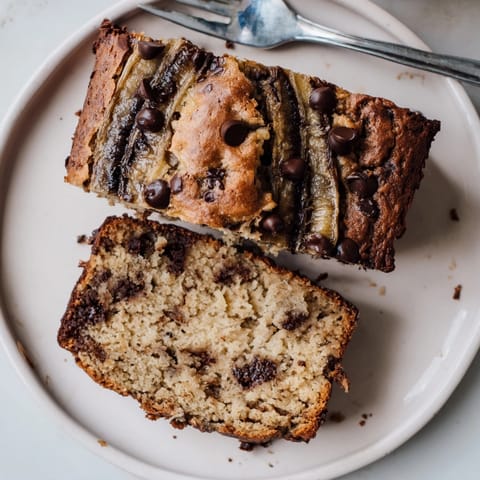 Freshly baked, fragrant Chocolate Chip Banana Bread—a comforting treat, sliced and ready to eat.