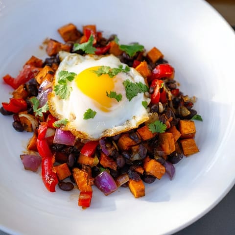 Vibrant skillet of Sweet Potato & Black Bean Breakfast Hash, seasoned and ready for a savory breakfast.