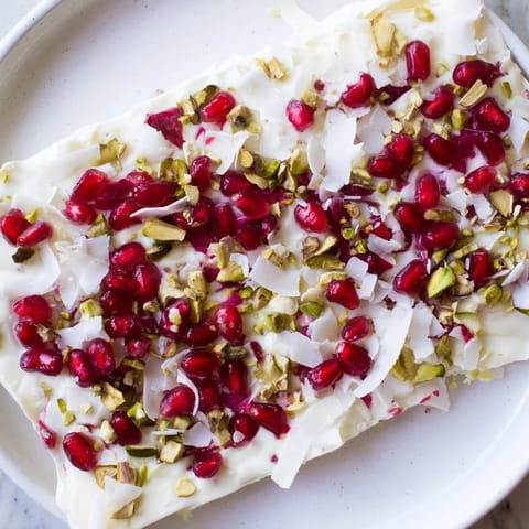 Vibrant frozen yogurt bark, layered with ruby pomegranate seeds, calls for a refreshing bite.
