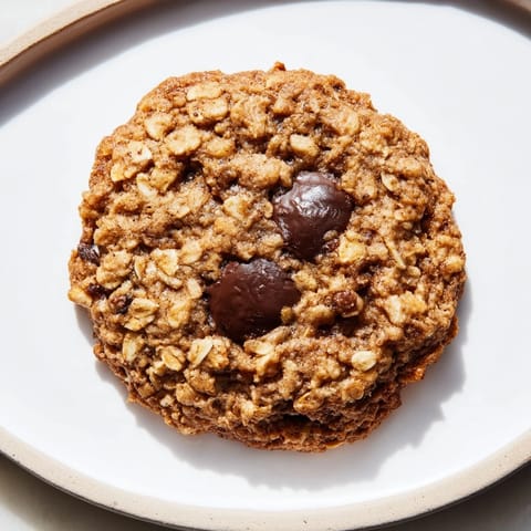 Freshly baked Oat-Banana Chocolate Chip Cookies with scattered chocolate chips, a delicious treat.