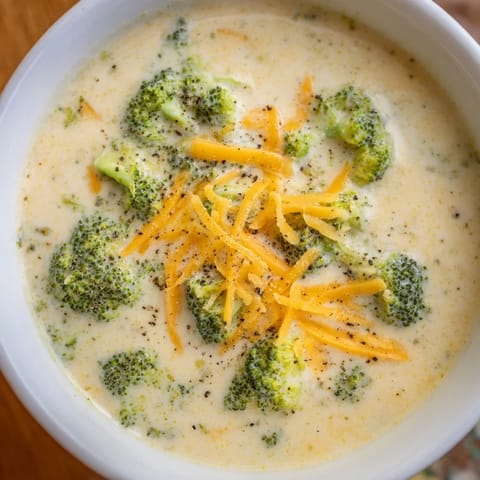 Rich and creamy Broccoli Cheese Soup, garnished and ready to serve with crusty bread.