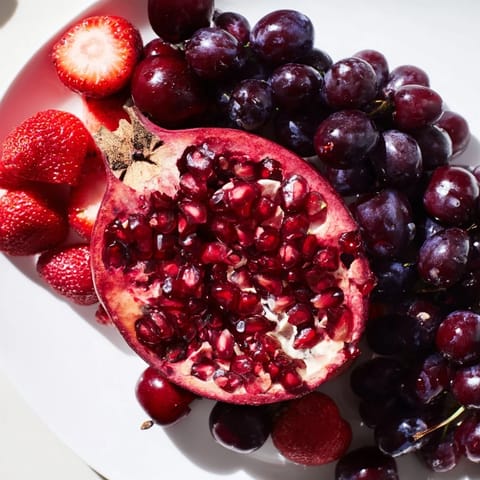 A gorgeous Pomegranate Pivot displays color-changing fruits arranged around a juicy, halved pomegranate centerpiece.