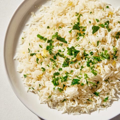 Steaming bowl of Garlic Butter Rice: buttery, savory, comforting, and flecked with fresh parsley for visual appeal.
