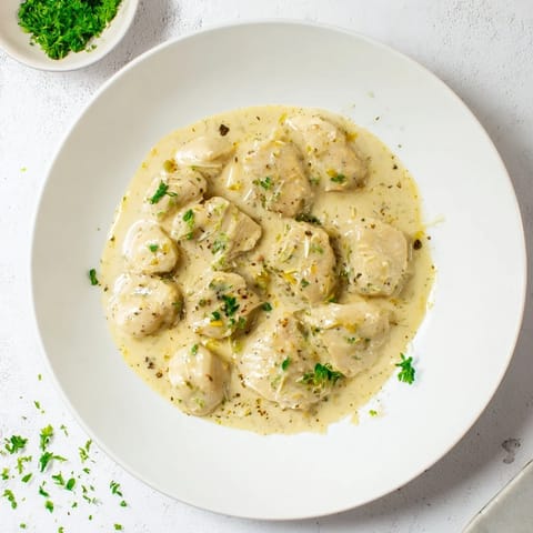 Savory Creamy Garlic Chicken Bites on a plate, served alongside fluffy rice and warm, crusty bread for dipping.