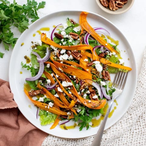 Vibrant orange carrot ribbons roasted to caramelized perfection, layered over greens and finished with feta.