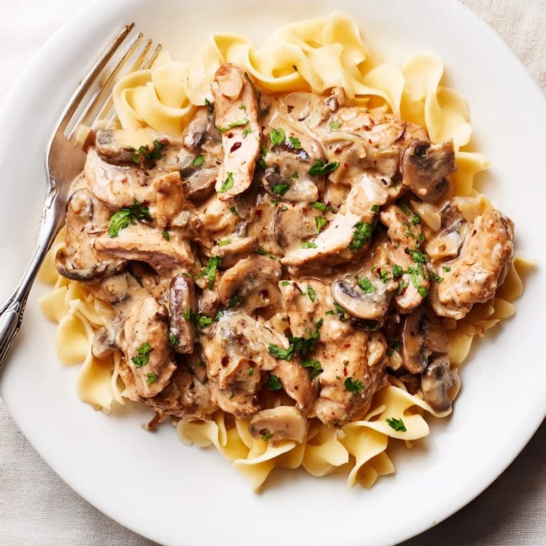 Savory Creamy Chicken Stroganoff featuring golden chicken in a luscious, creamy sauce over rice.