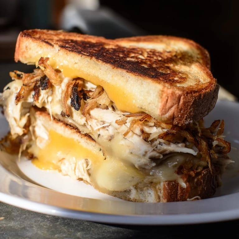 A hearty Crispy Shallot Chicken Grilled Cheese, served hot, with visible crispy shallots and savory chicken filling.