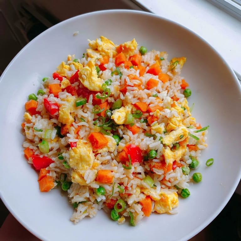 A delicious bowl of egg fried rice with peas and carrots, a quick weeknight dinner option.