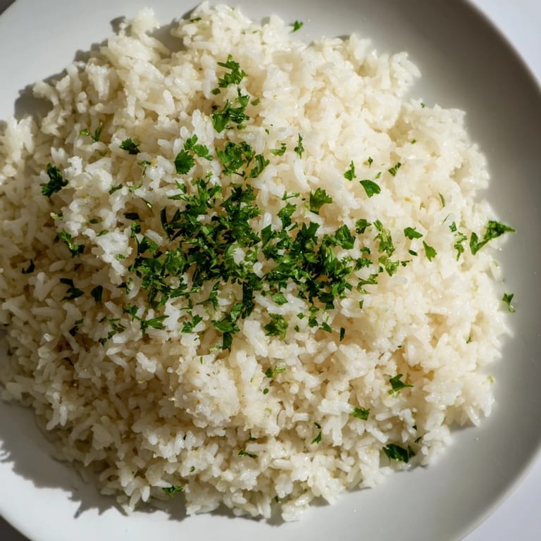 A close-up view of Garlic Butter Rice, each grain glistening, suggesting a delicious side dish made with garlic.