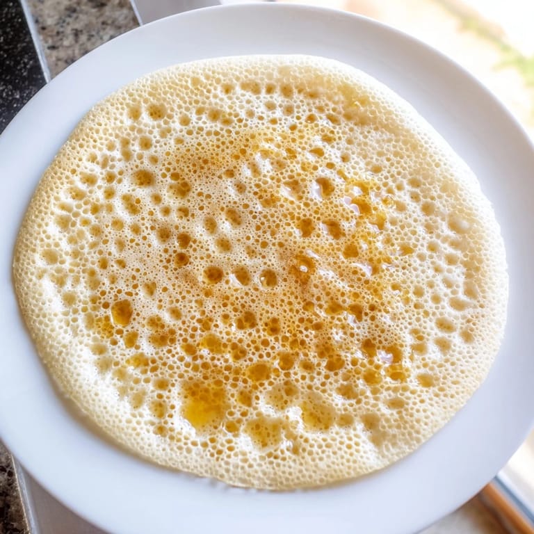 Warm Moroccan Baghrir crepes, served with melted butter and honey, offer a delightful, sweet breakfast.